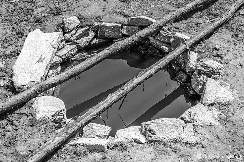 A stone-lined traditional spring-based water source in a Particularly Vulnerable Tribal Group (PVTG) hamlet in Gumla district, Jharkhand, India
